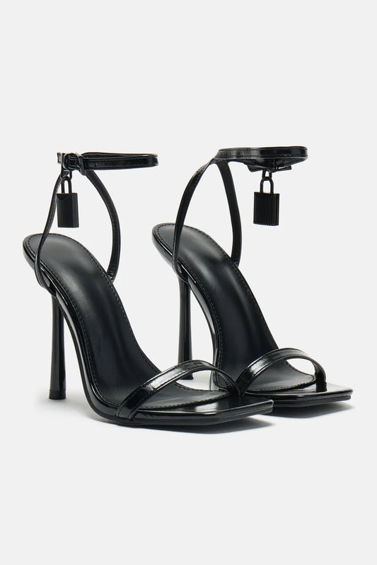 Sandalias de tacón minimalista de color negro de la marca Vera Serrat, con diseño elegante y sencillo.