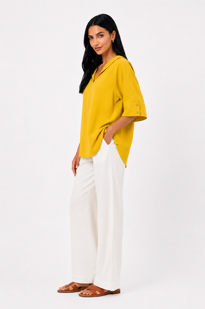 Blusa blanca de corte fluido de la marca Vera Serrat, con diseño elegante y tejido suave, en una modelo usando la prenda.