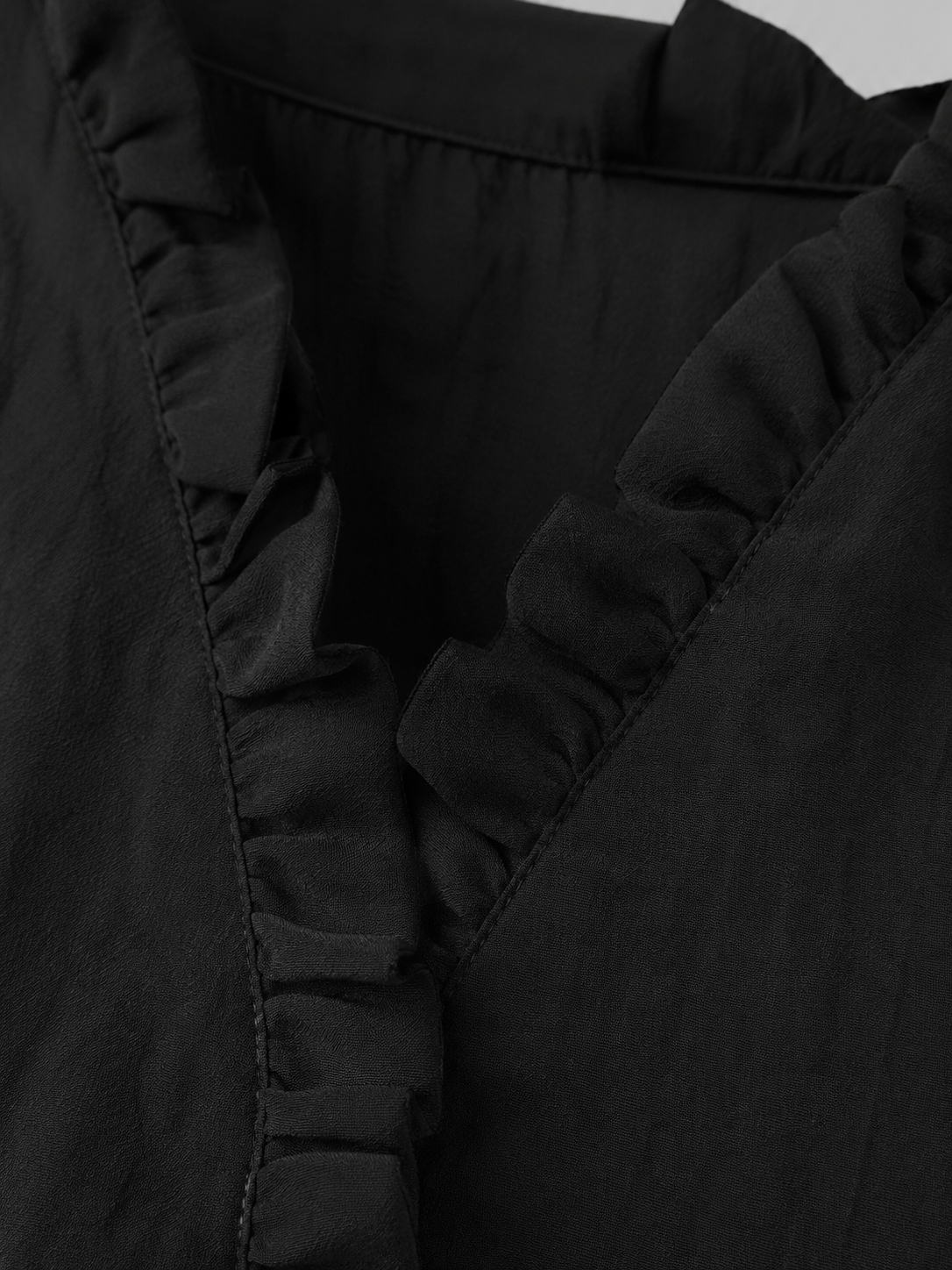 Camisa de algodón y lino con volantes de la marca Vera Serrat, mostrando detalles de la prenda en color blanco.