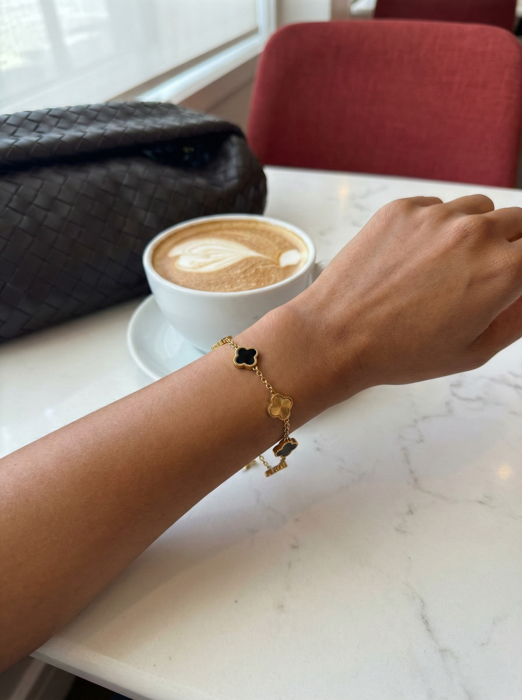 Pulsera trévol de NOA FERRER con diseño de símbolo de Gemini, en tonos dorados y detalles elegantes.
