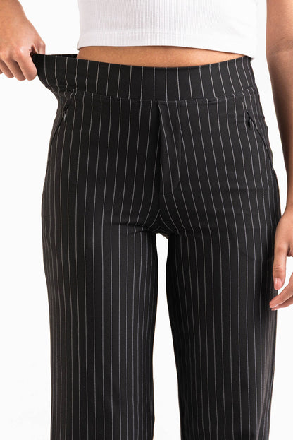 Pantalón elástico de tiro medio de la marca MADLADY, en color negro, con cintura cómoda y ajuste ajustado.