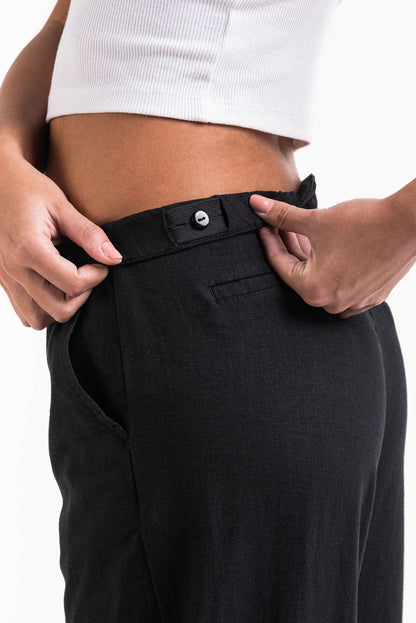 Pantalón ancho de lino MADLADY en color beige, con cintura elástica y bolsillos laterales, para un estilo cómodo y elegante.