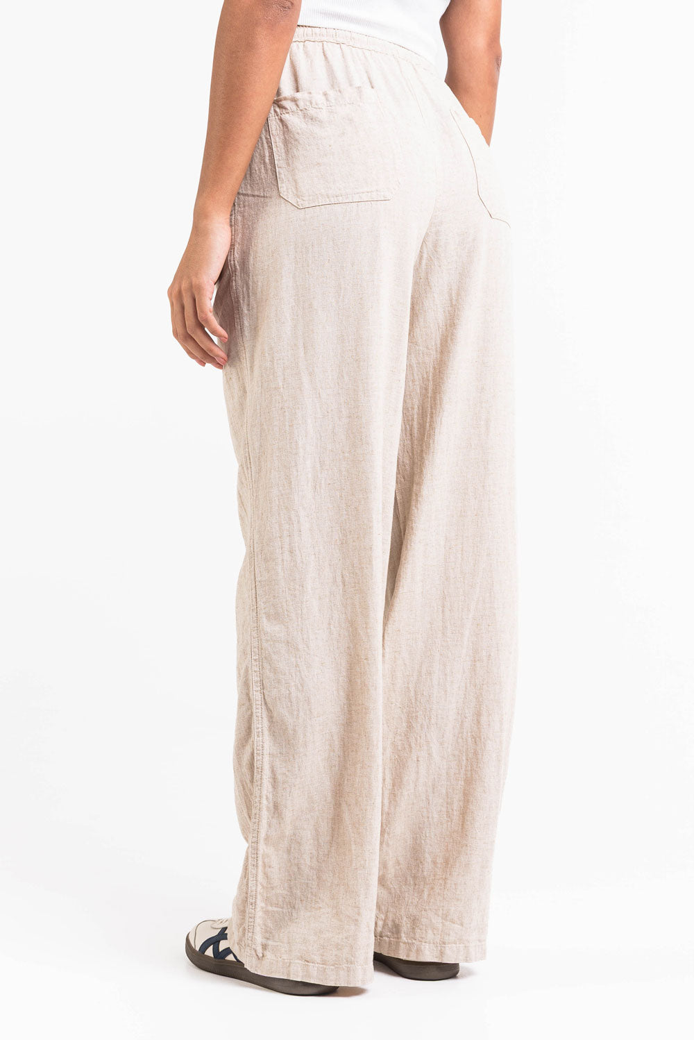 Pantalón de lino recto de tiro alto de MADLADY, en color neutro, mostrando su diseño cómodo y elegante.