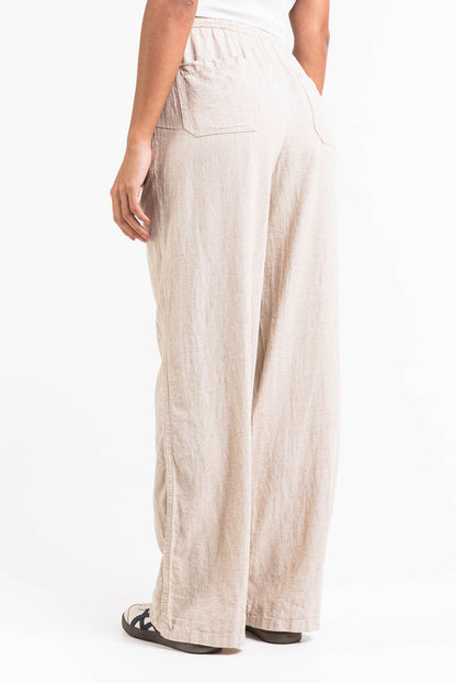 Pantalón de lino recto de tiro alto de MADLADY, en color neutro, mostrando su diseño cómodo y elegante.