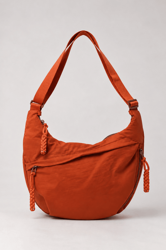 Bolso bandolera de nylon con diseño media luna naranja de Vera Serrat, con correa ajustable y detalles en contraste.