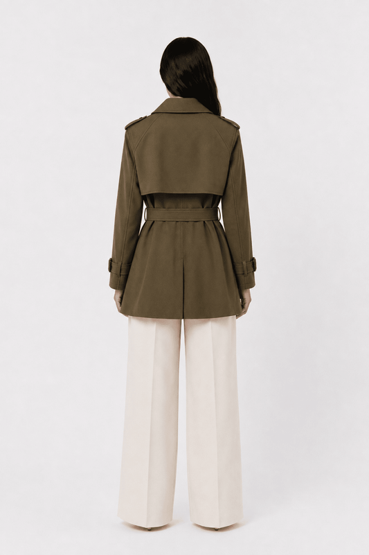 Abrigo trench corto con cinturón de Vera Serrat, en color beige, mostrando el diseño elegante y cinturón ajustable.